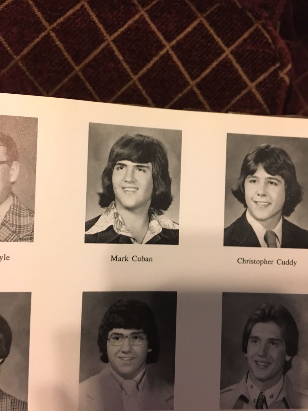 A yearbook page with black-and-white portrait photos of two young men labeled "Mark Cuban" and "Christopher Cuddy." Both have medium-length hair and are wearing collared shirts and jackets.