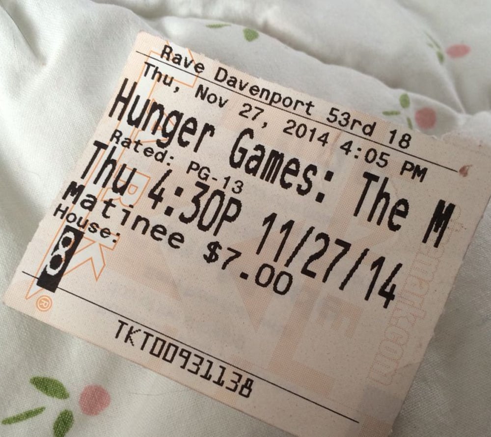 A movie ticket for "Hunger Games: The M" at Rave Davenport, dated Thursday, November 27, 2014, for a 4:30 PM matinee showing. The ticket price is $7.00, and it is rated PG-13.