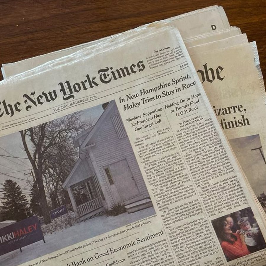 A close-up of The New York Times newspaper dated January 23, 2024, featuring headlines about the New Hampshire primary and Nikki Haley’s campaign. The front page shows a photo of a house with a "Haley" sign in the yard.