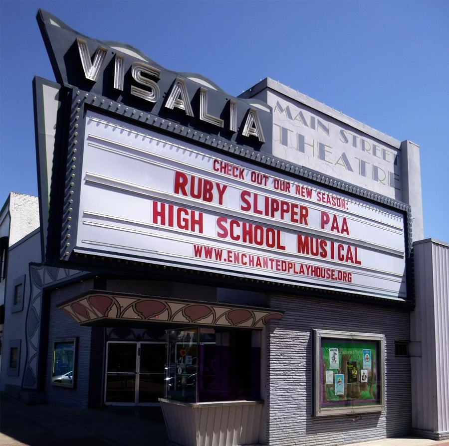 Marquee outside Visalia Main Street Theatre announces "Check out our new season: Ruby Slipper PAA, High School Musical" with a website link below. The building has a vintage design under a clear blue sky.