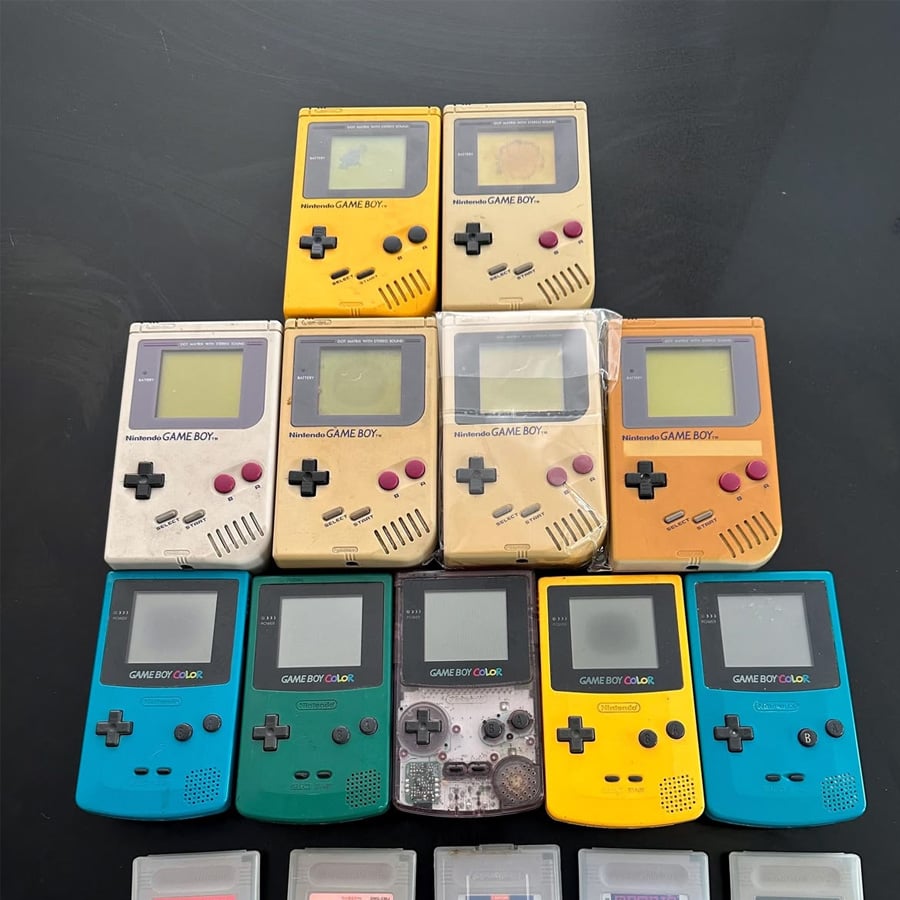 Ten classic Nintendo Game Boy handheld consoles are arranged in two rows by model and color, with several game cartridges partially visible at the bottom of the image.