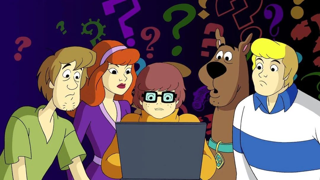 The Scooby-Doo gang—Shaggy, Daphne, Velma (at a laptop), Scooby-Doo, and Fred—look confused while gathered around a computer, with colorful question marks floating on a dark background.