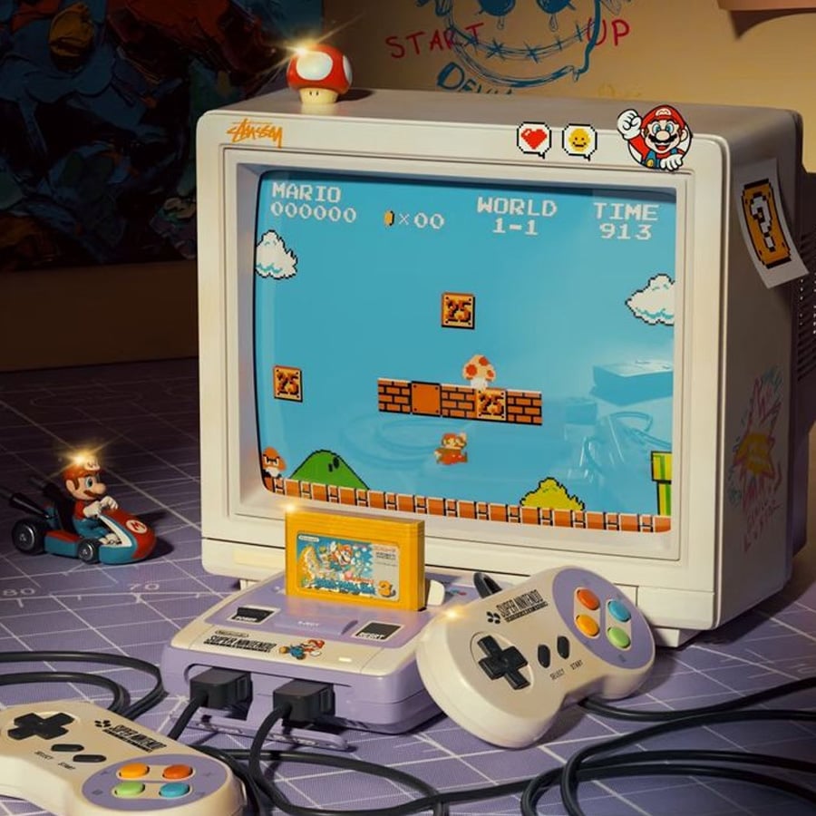 A retro gaming setup features a CRT monitor displaying Super Mario Bros., a Super Nintendo console with two controllers, a yellow game cartridge, Mario figurines, and various Mario-themed decorations on a purple desk.