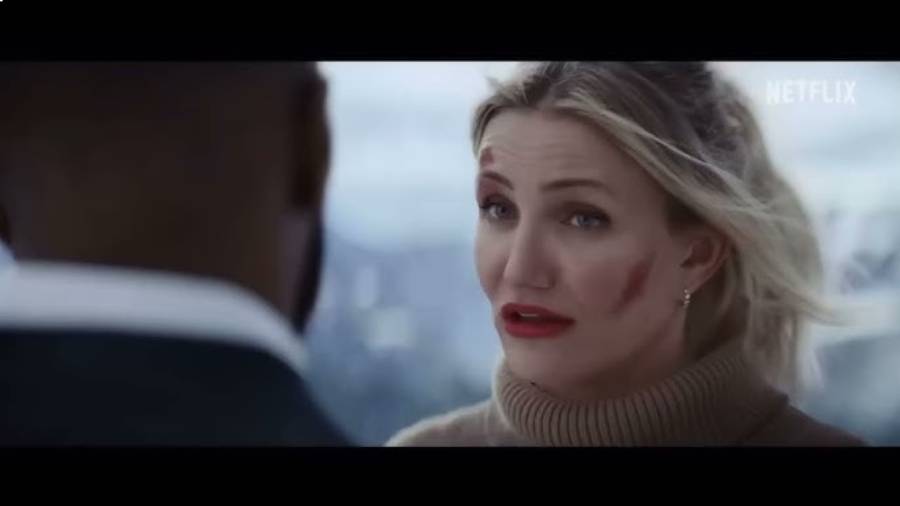 A woman with blonde hair and red lipstick, wearing a brown turtleneck sweater with smudged makeup on her face, looks at a man whose back is to the camera. The Netflix logo is visible in the top right corner.
