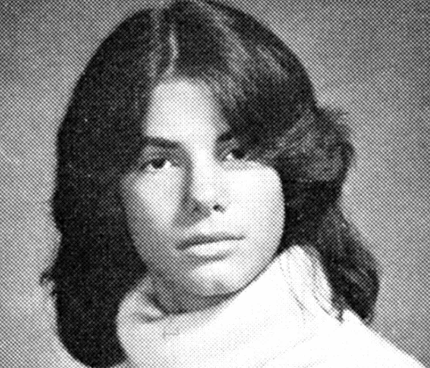 Black and white portrait of a young person with medium-length dark hair, wearing a light-colored turtleneck sweater, looking slightly off to the side against a plain backdrop.