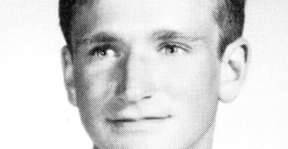 Black and white yearbook-style portrait of a young man with short, neatly combed hair, wearing a light-colored jacket, shirt, and tie, facing forward with a neutral expression.