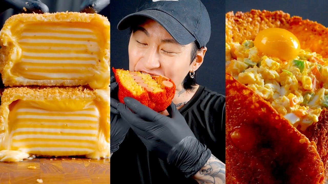 A person wearing a black cap and gloves eats a large, colorful fried snack. On the left, there are stacked fried cheese slices, and on the right, a crispy shell filled with scrambled eggs and topped with a raw egg yolk.
