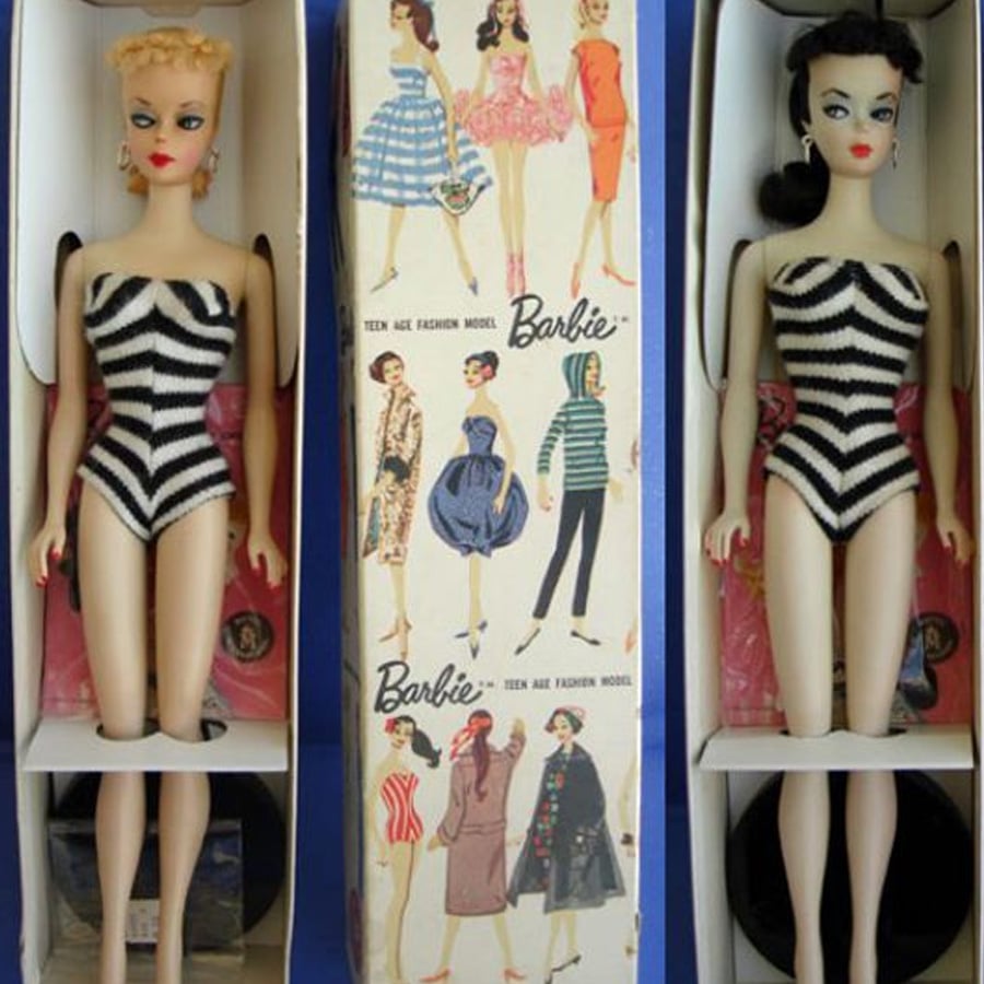 Two vintage Barbie dolls in black-and-white striped swimsuits are displayed on either side of a box illustrated with various Barbie outfits and the “Barbie” logo. The dolls have different hair colors and styles.