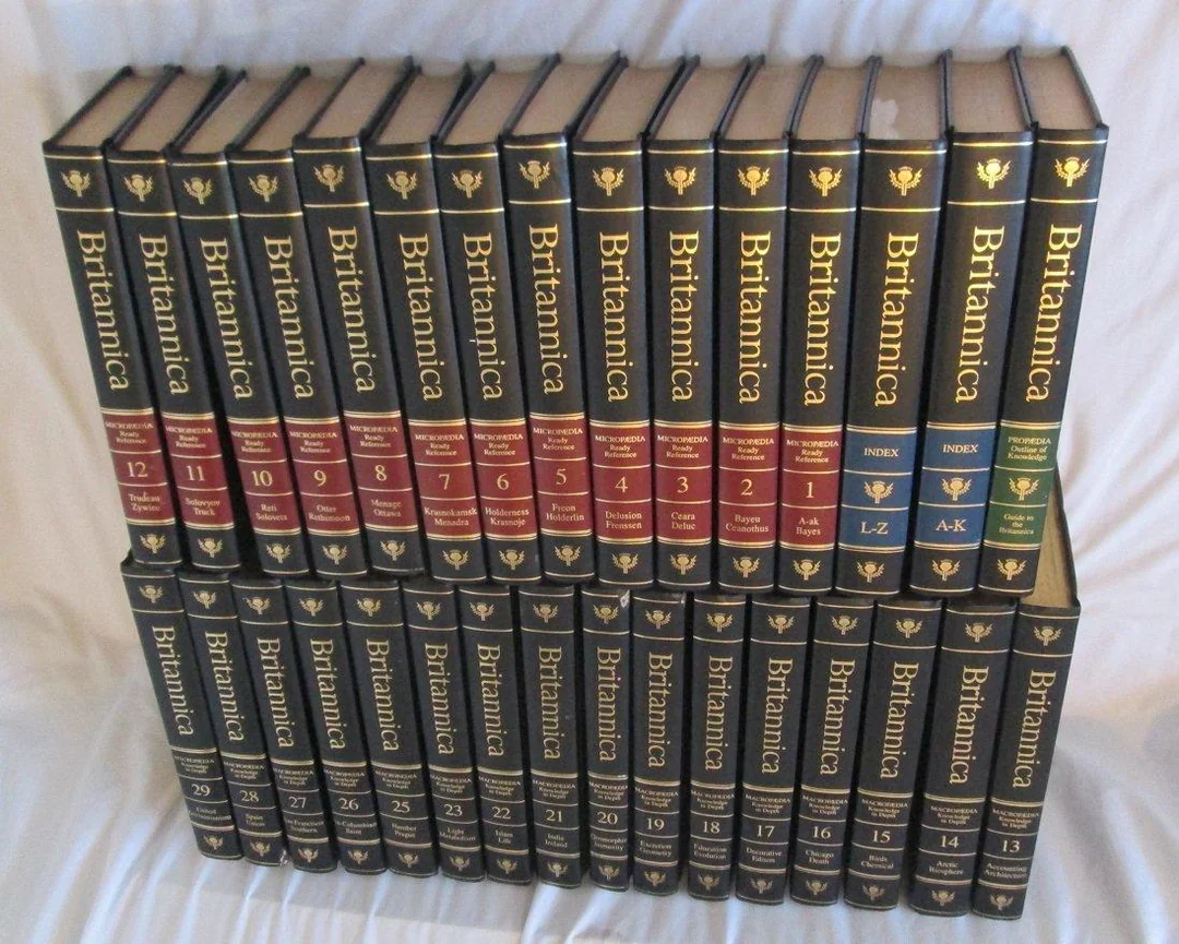 A complete 30-volume set of Encyclopedia Britannica arranged in two rows with blue and gold spines, volume numbers and titles clearly visible on each book.