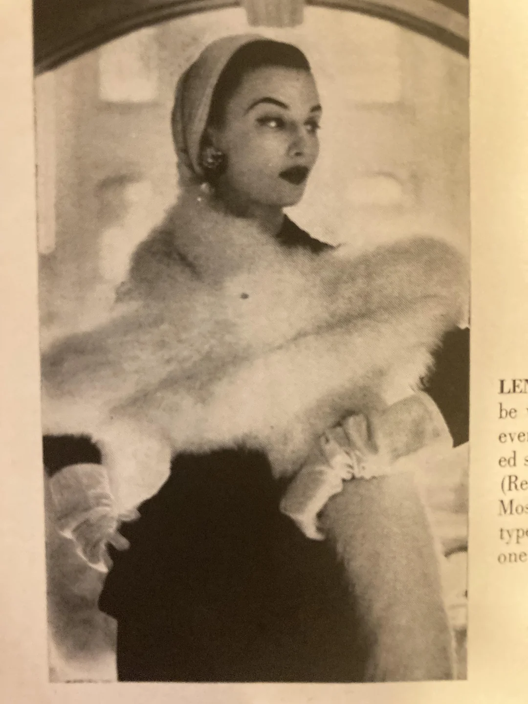 A woman poses elegantly in vintage attire, wearing a headscarf, gloves, and a luxurious fur shawl draped over her shoulders, exuding 1950s glamour.