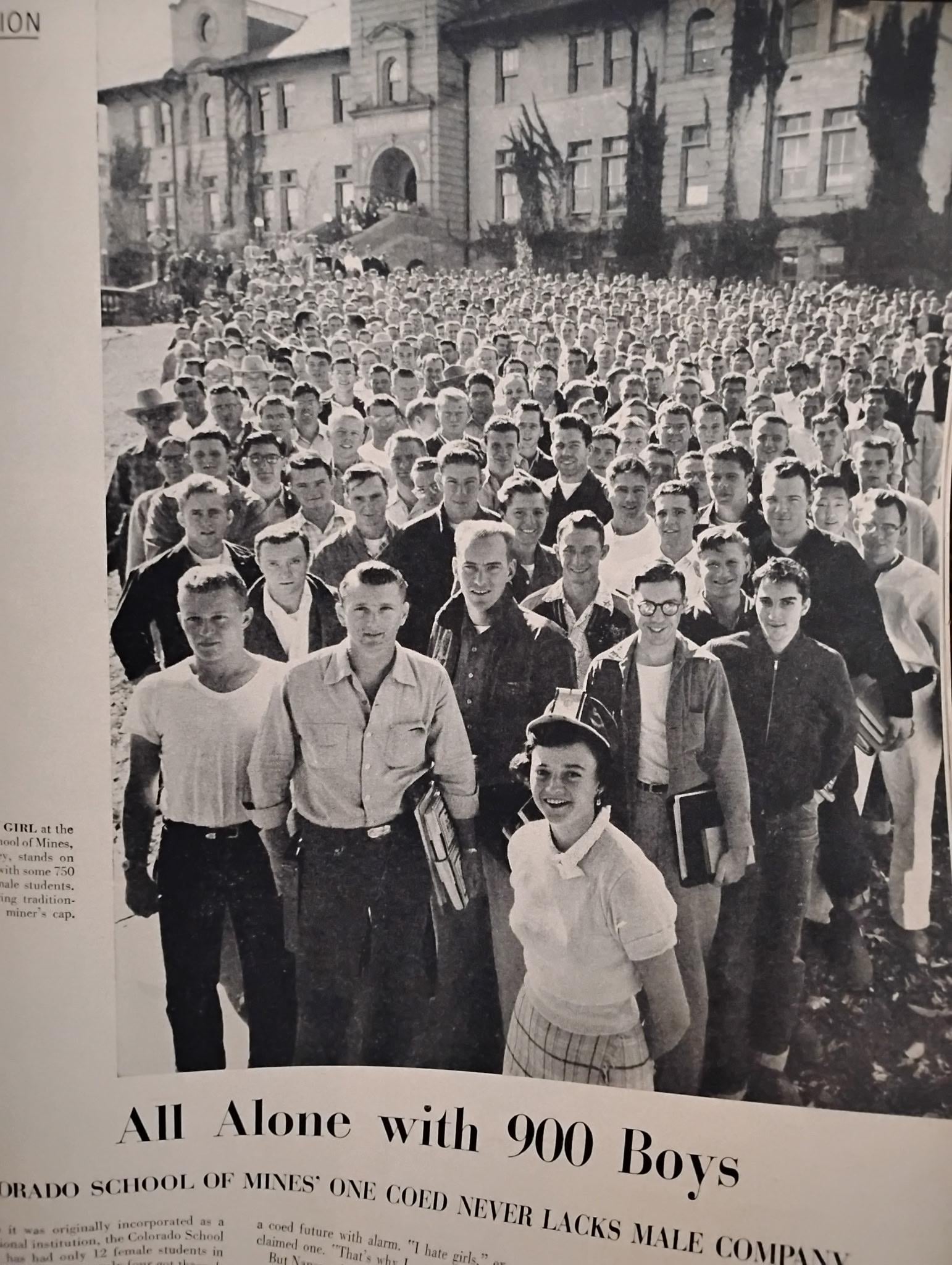 A young woman stands smiling in front of a large group of young men outside a school building, with the headline “All Alone with 900 Boys” beneath the photo.