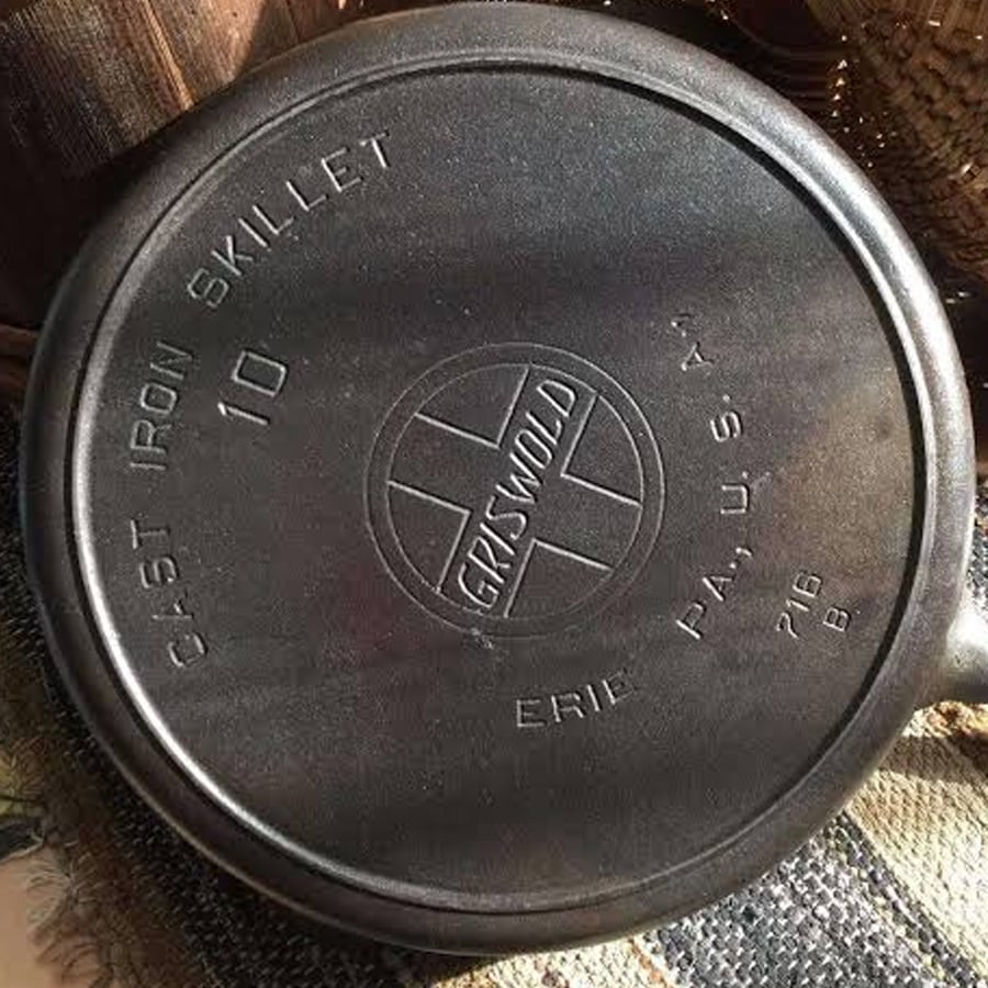 A close-up of the bottom of a Griswold cast iron skillet, showing the words “CAST IRON SKILLET 10 GRISWOLD ERIE PA U.S.A. 716 B” stamped on it.