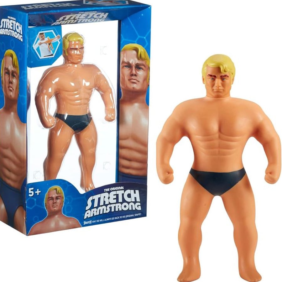 Stretch Armstrong action figure with blond hair and black trunks, shown both inside its blue packaging and out of the box. The packaging displays the product name and is recommended for ages 5 and up.