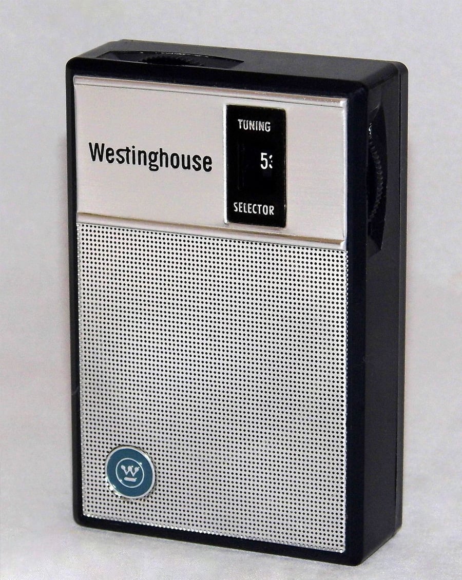 A vintage Westinghouse portable transistor radio with a silver speaker grille, a small tuning window, and a black-and-white exterior, standing upright on a white background.