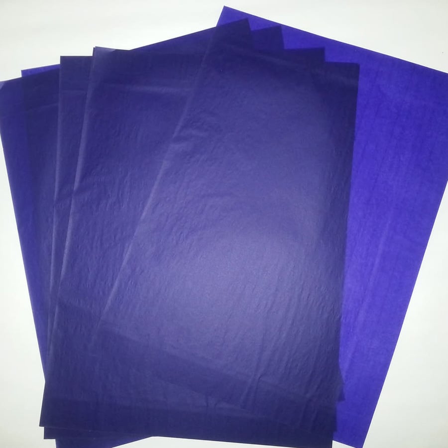 Five sheets of blue carbon paper are stacked and spread out on a white background, with visible texture and slight transparency.