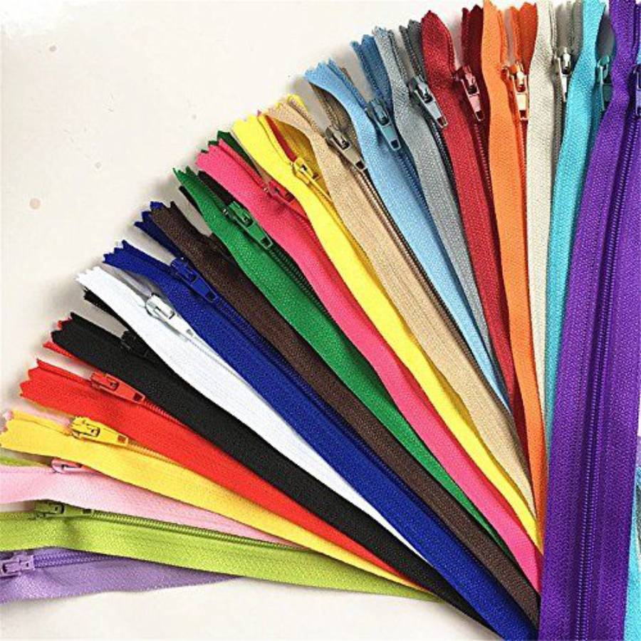 A fan-shaped arrangement of zippers in various bright colors, including red, yellow, green, blue, purple, orange, white, black, brown, and beige, displayed on a light background.