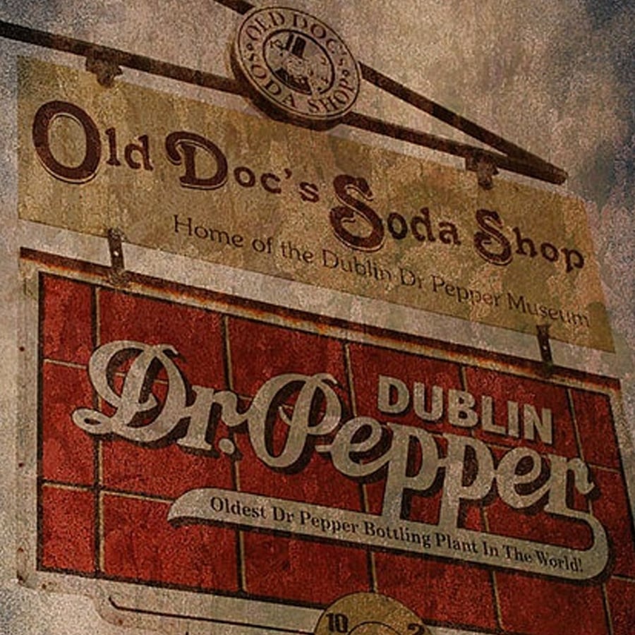 A weathered sign for "Old Doc's Soda Shop" and "Dublin Dr Pepper," advertising the oldest Dr Pepper bottling plant and Dublin Dr Pepper Museum.