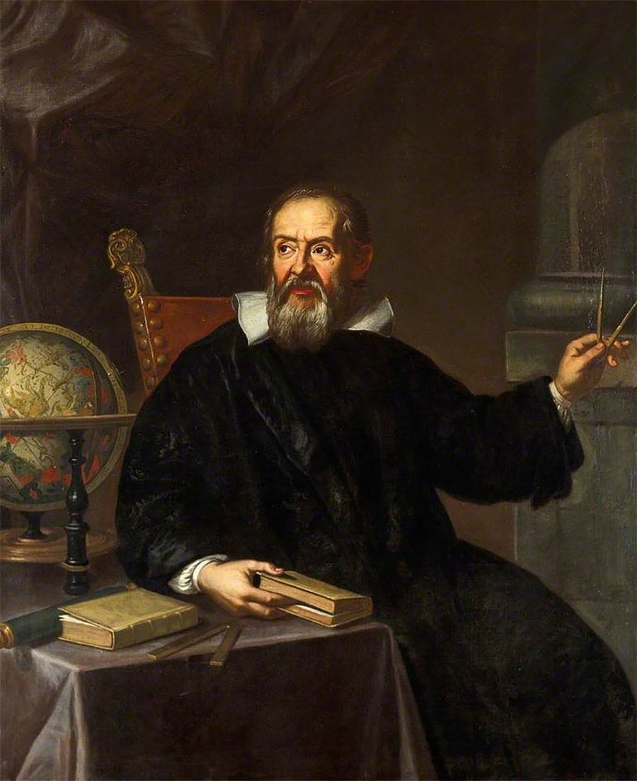 A bearded man in dark robes sits at a table with books and a globe, holding a compass in one hand and a book in the other, looking thoughtfully to the side.