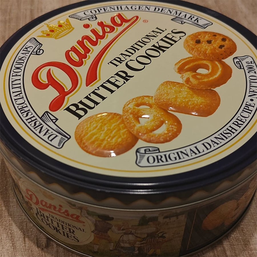 A round tin of Danisa Traditional Butter Cookies with images of cookies on the lid and text describing them as original Danish recipe.