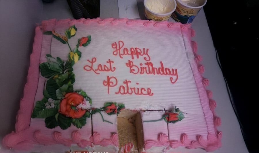 A rectangular cake with pink icing, flower decorations, and the words "Happy Last Birthday Patrice." A slice is missing, and two tubs of ice cream are nearby.