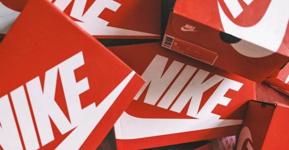 Several red Nike shoe boxes are stacked haphazardly, prominently displaying the white Nike logo and branding on their sides and lids.
