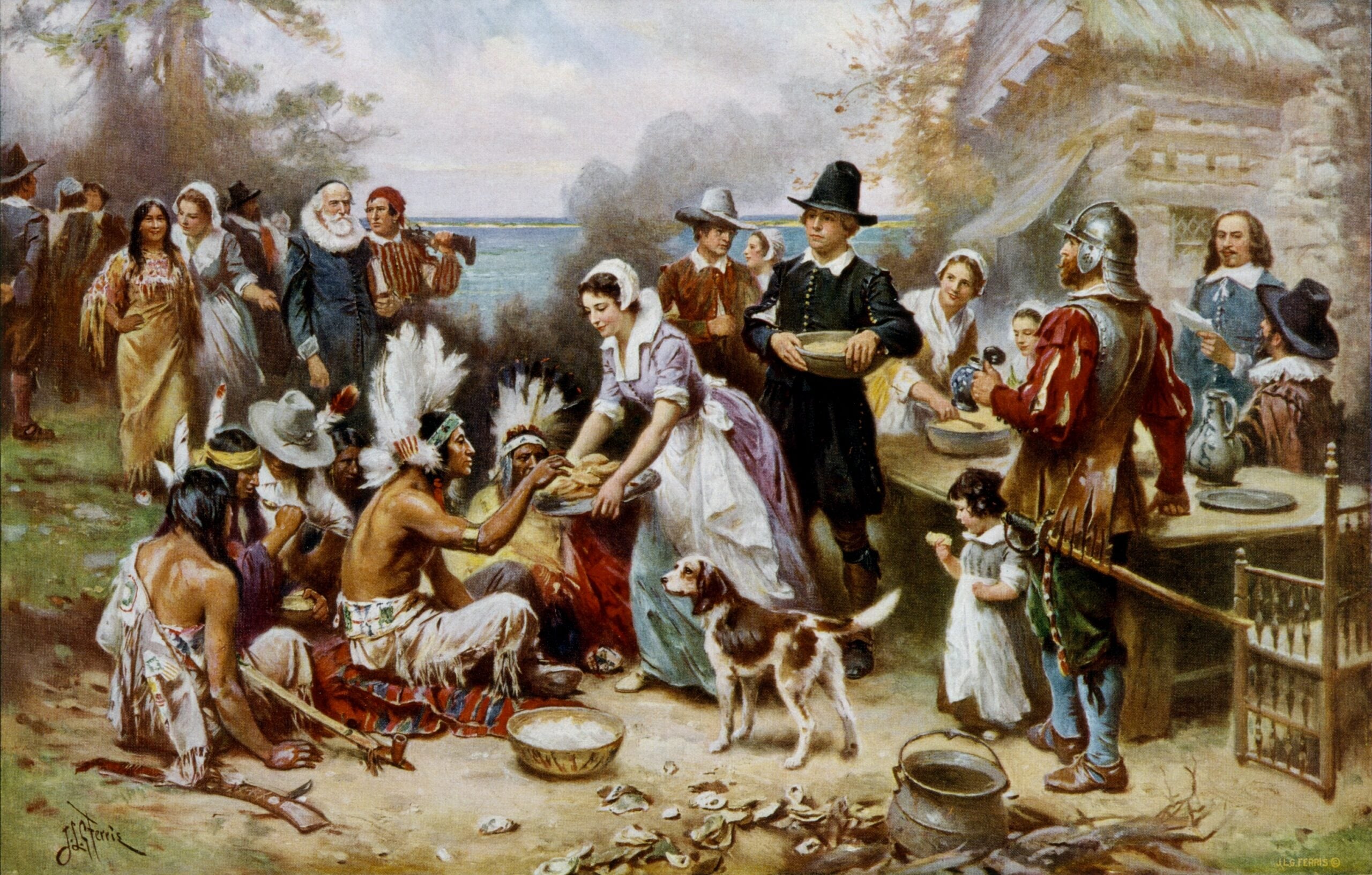 Pilgrims and Native Americans share food outdoors at a long table, with women serving and men standing nearby. A dog is in the center, and trees and a house are in the background. The mood is festive and communal.