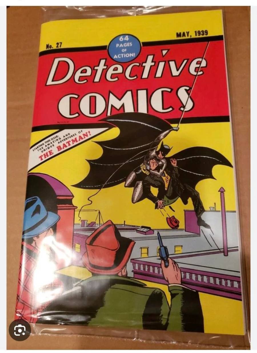 A sealed copy of Detective Comics No. 27, featuring Batman swinging over a rooftop as two armed criminals look up, with a bold red and yellow cover design.