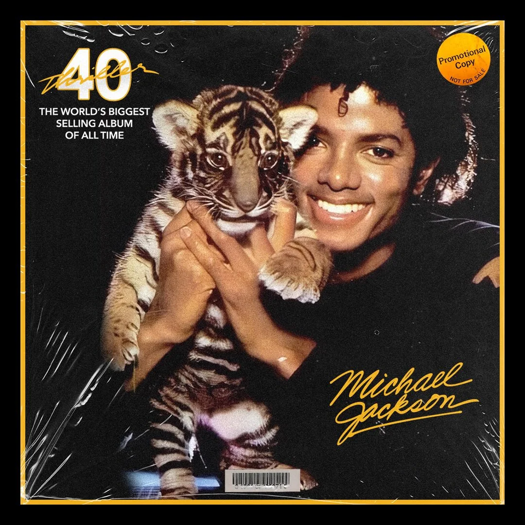 Michael Jackson, smiling, holds a tiger cub on the cover of an album celebrating the 40th anniversary of “Thriller,” with gold text and a promo sticker in the corner.