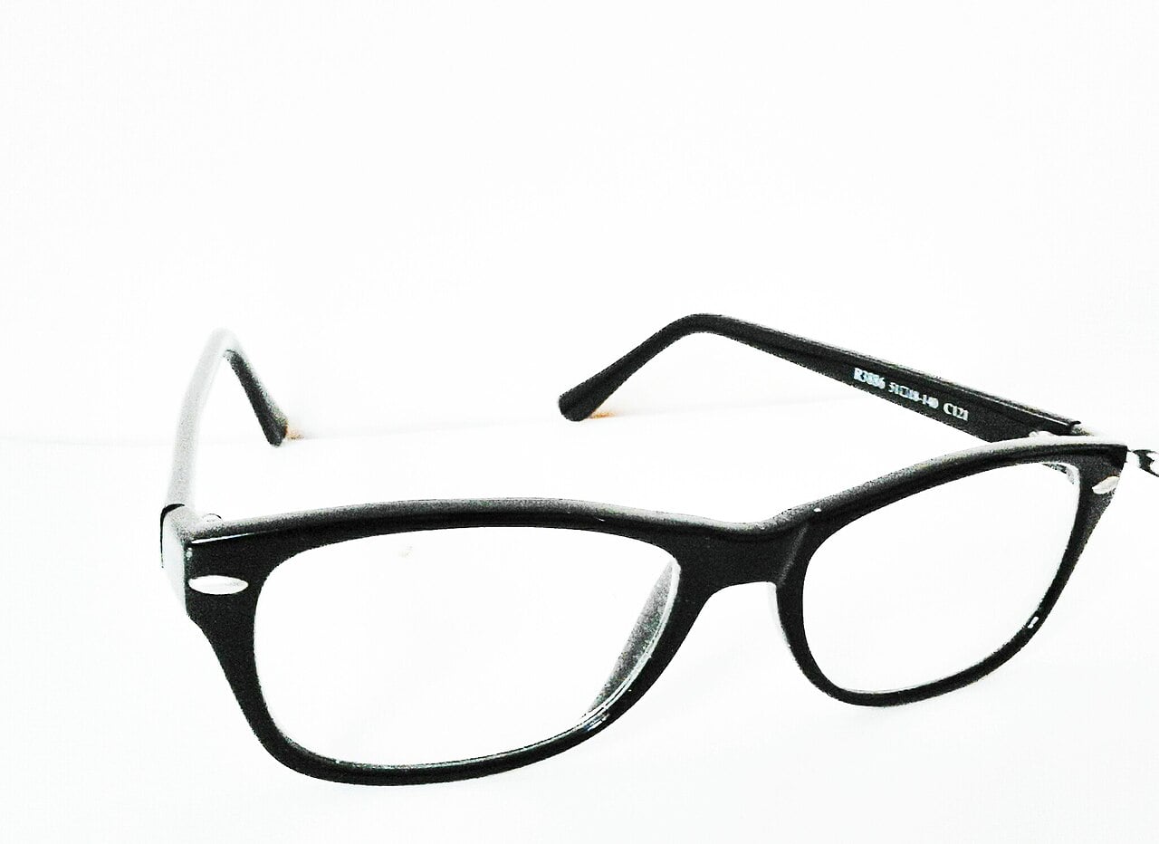 A pair of black-rimmed eyeglasses with rectangular lenses is displayed against a plain white background.