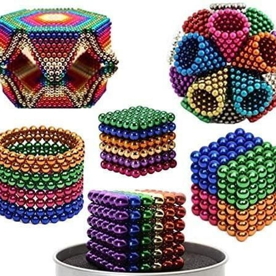 Colorful magnetic balls arranged in various geometric shapes, including cubes, rings, and complex patterns, displayed on a white background.