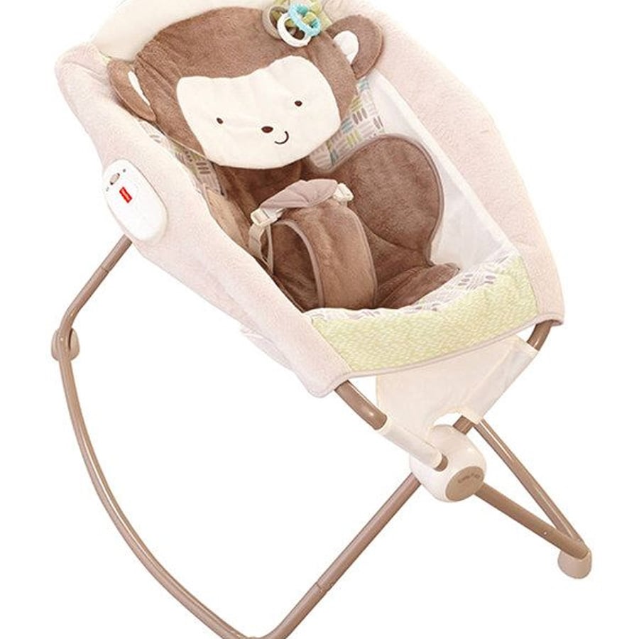 Baby rocker seat with a soft brown monkey face design, beige sides, and a harness. It has a light frame and fabric seat, suitable for infants.