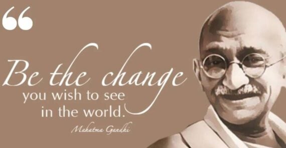 Portrait of Mahatma Gandhi with the quote, “Be the change you wish to see in the world. Mahatma Gandhi,” in white cursive and print on a brown background.