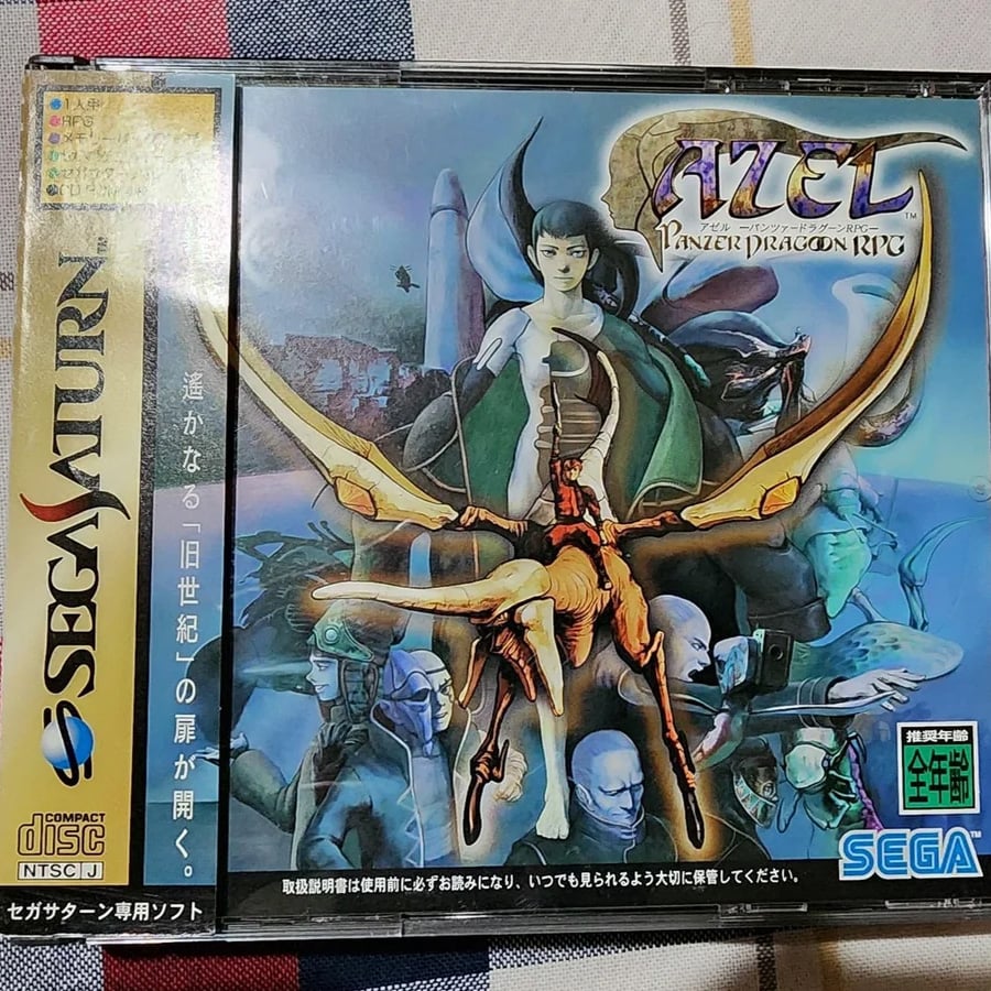 Cover art for “Panzer Dragoon RPG” on Sega Saturn, featuring a woman riding a dragon, with blue-skinned characters and fantastical landscapes in the background. The Sega and CD logos appear on the left side.