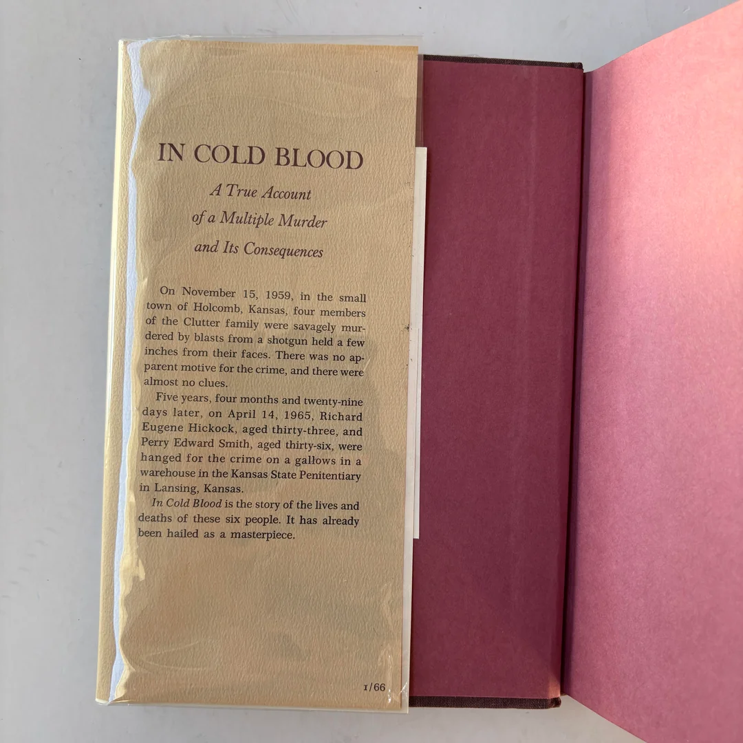Book cover with a description of “In Cold Blood” by Truman Capote. The text details the 1959 Clutter family murder in Kansas and its aftermath. The page is cream-colored with a maroon book cover visible behind it.