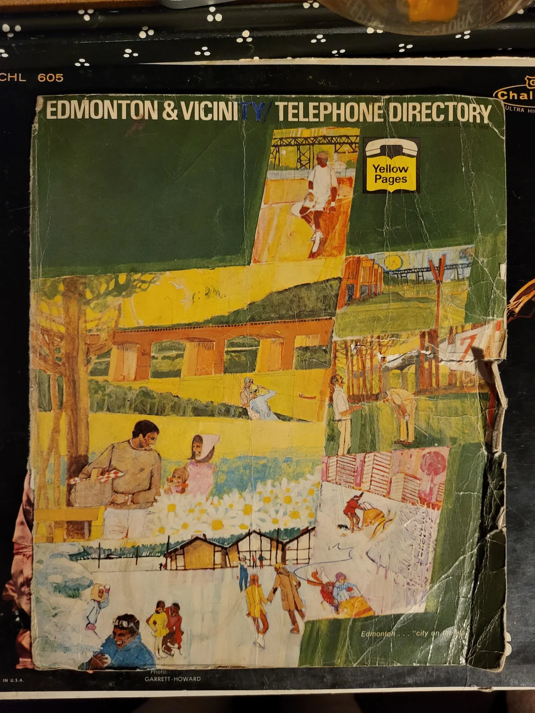 Worn cover of an Edmonton & Vicinity Telephone Directory with Yellow Pages. The illustrated collage shows people at parks, a playground, and outdoor activities under a green background.