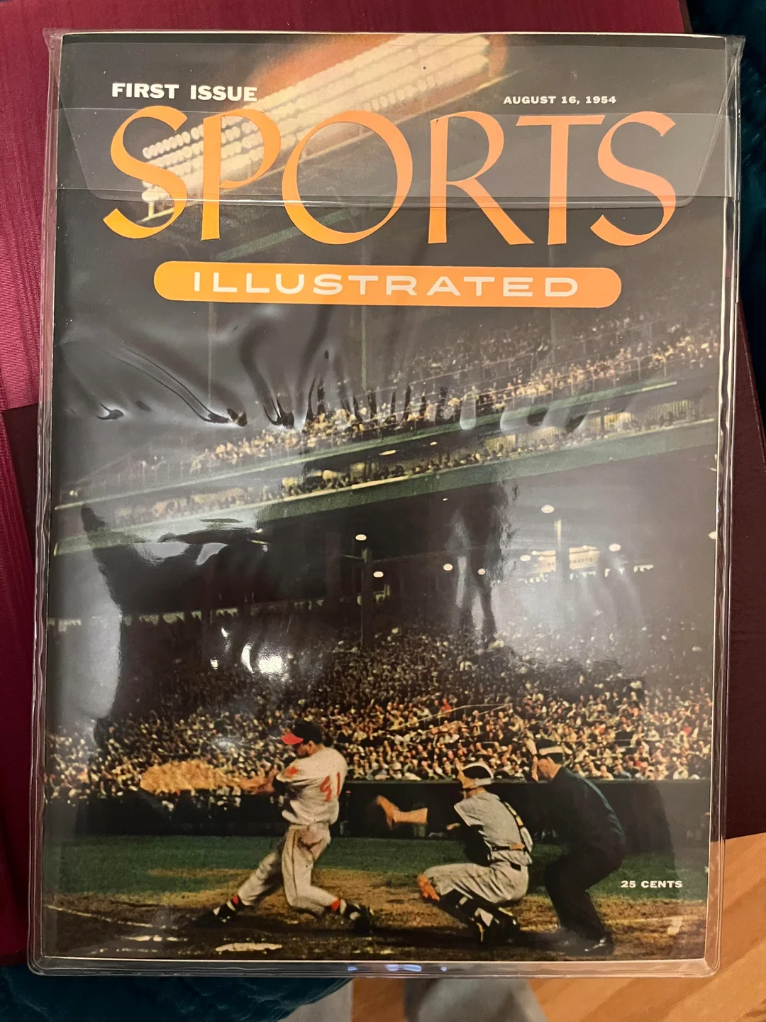 The first issue of Sports Illustrated from August 16, 1954, features a baseball game on the cover, showing a batter, catcher, umpire, and a crowded stadium. The magazine is priced at 25 cents.