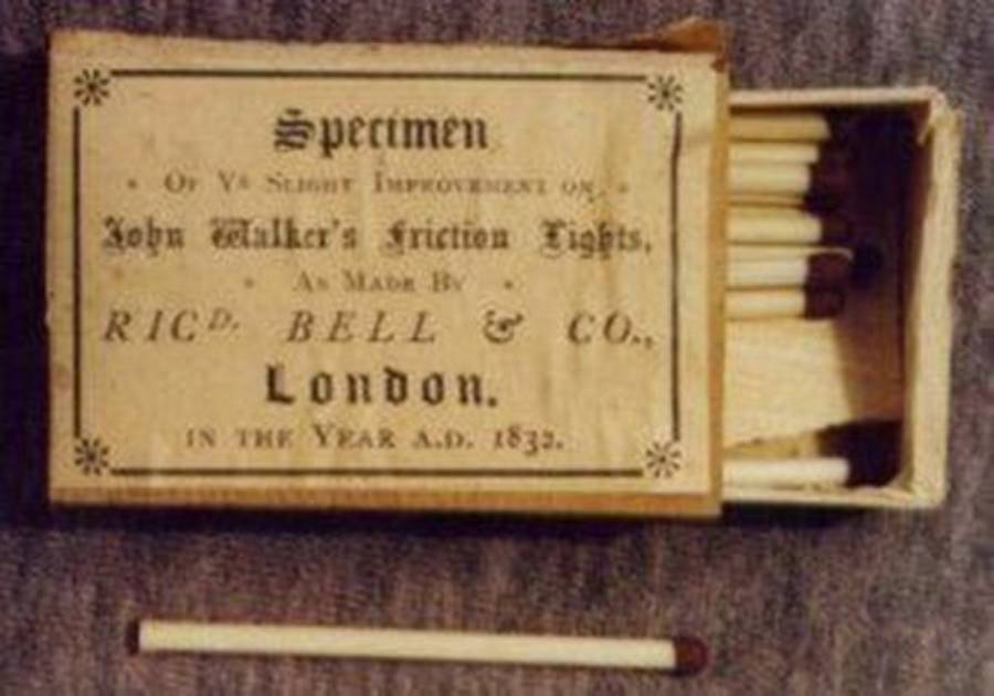 An open box of vintage matches labeled “Specimen of ya slight improvement on John Walker’s Friction Lights, as made by Richd. Bell & Co., London, in the year A.D. 1832,” with one match lying outside.