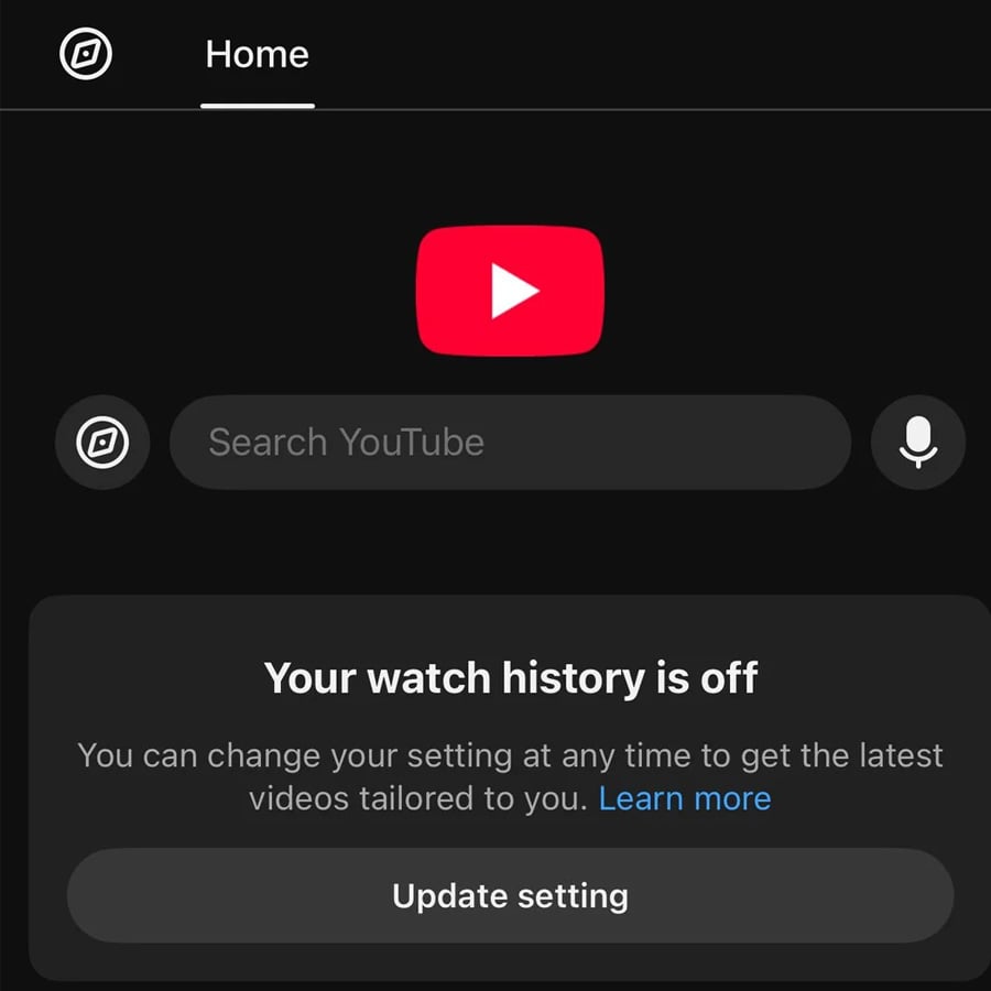 YouTube app home screen in dark mode showing a message: “Your watch history is off” with options to learn more or update settings. The YouTube logo and a search bar are visible at the top.