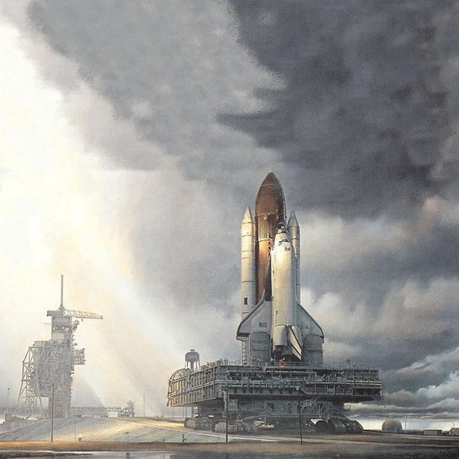 A space shuttle on a mobile launch platform is being transported across a runway under a dramatic, cloudy sky, with sunlight breaking through in the background.