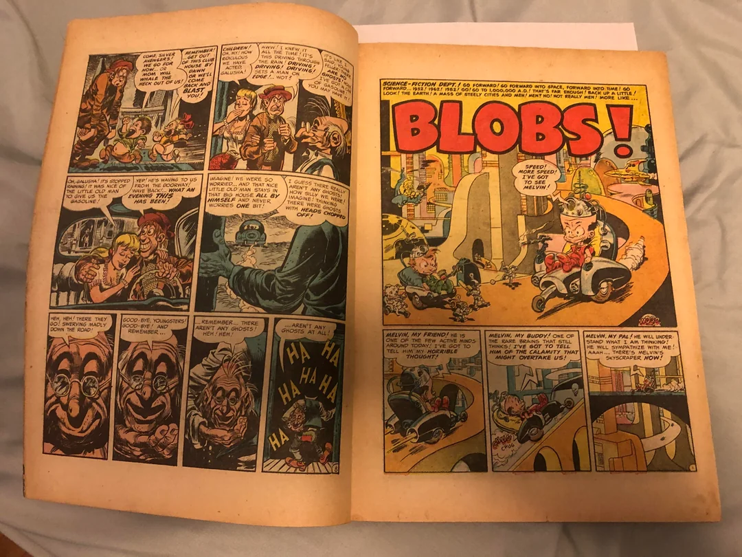 An open vintage comic book shows black-and-white panels on the left and a colorful page on the right titled “BLOBS!” with cartoon characters in a city setting. The pages appear slightly yellowed with age.