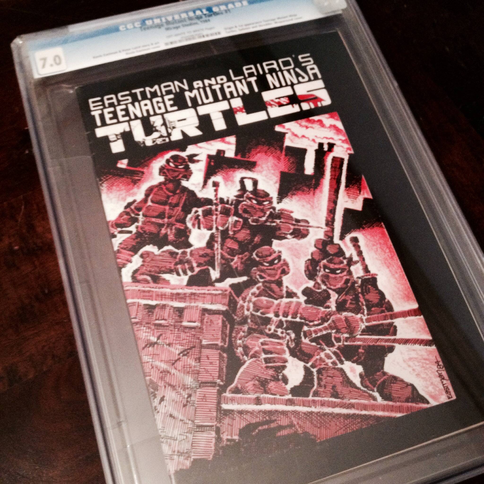 A graded Teenage Mutant Ninja Turtles comic by Eastman and Laird, encased in plastic. The cover shows the turtles in red and black tones, standing ready for battle on a city rooftop.