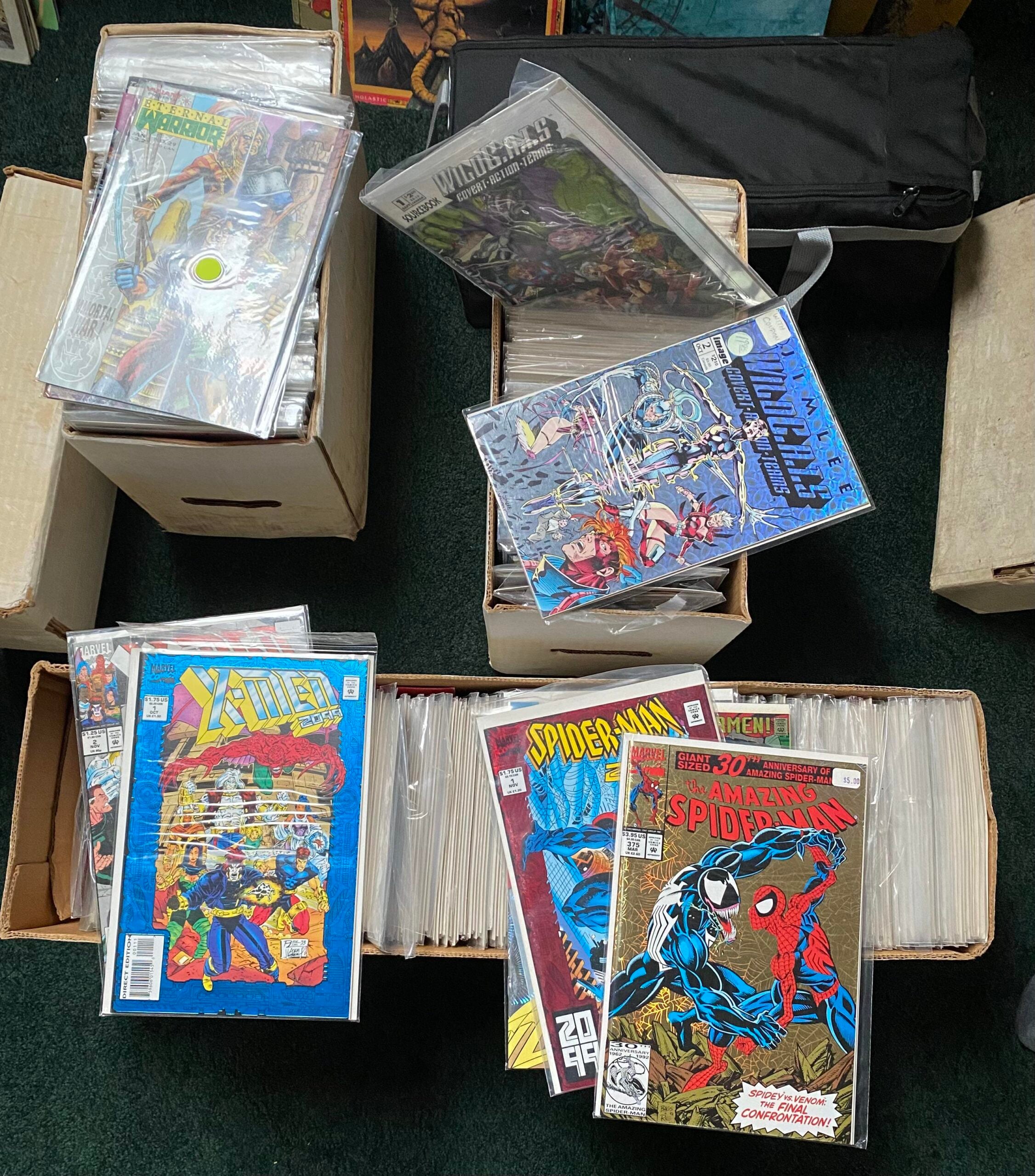 Several open boxes and stacks of comic books, including X-Men and Spider-Man issues in plastic sleeves, arranged on a dark surface with a black bag in the background.
