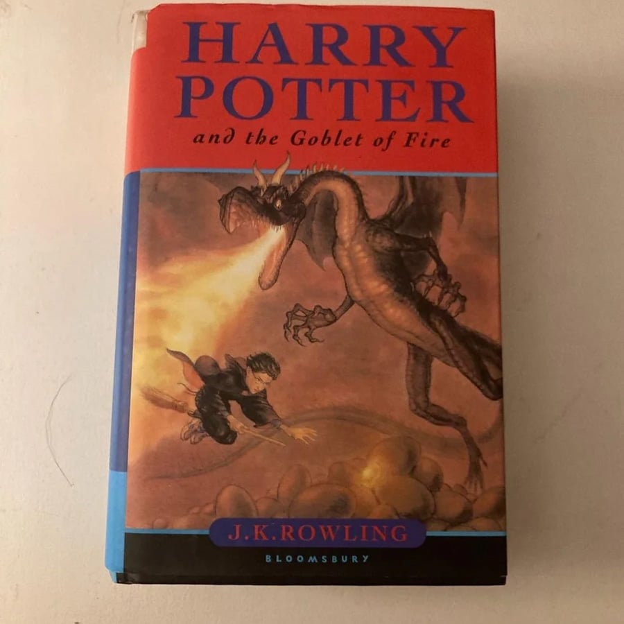 The cover of “Harry Potter and the Goblet of Fire” shows Harry dodging fire from a dragon. The title and author, J.K. Rowling, are displayed above and below the illustration.
