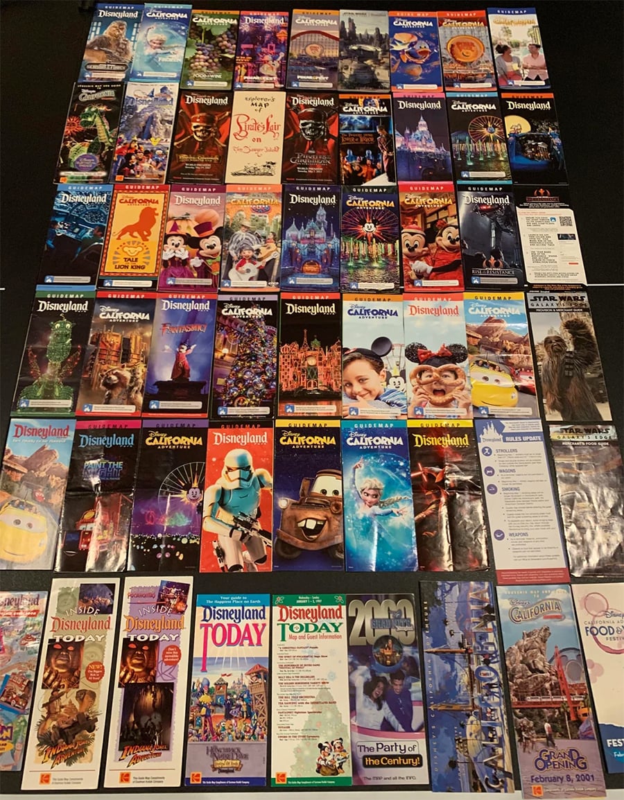 A collection of Disneyland and Disney California Adventure park maps and guides arranged in a neat grid, showcasing various covers with colorful artwork and characters.