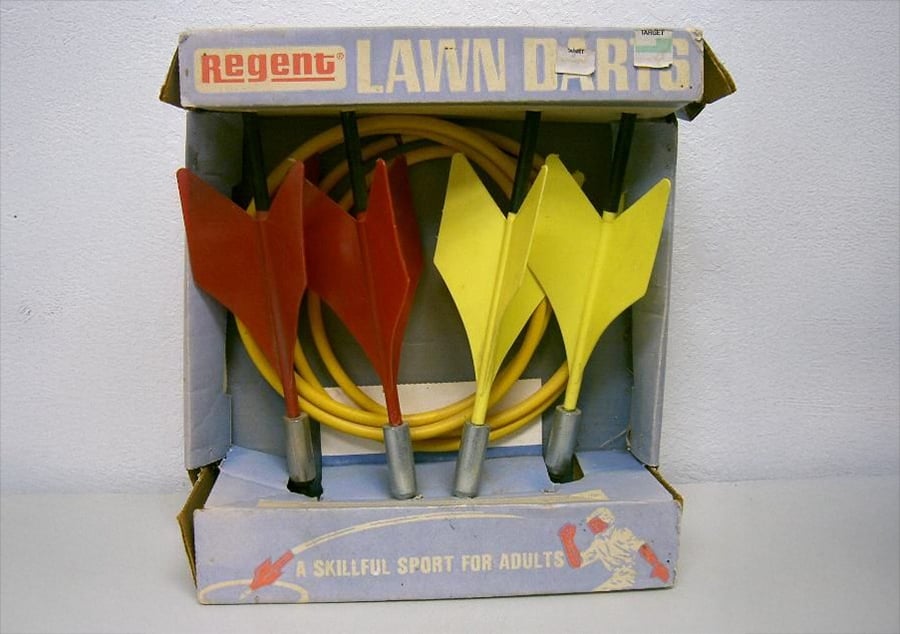 Vintage Regent Lawn Darts set in original box, featuring two red darts, two yellow darts, and yellow target rings. Box reads “A skillful sport for adults.”