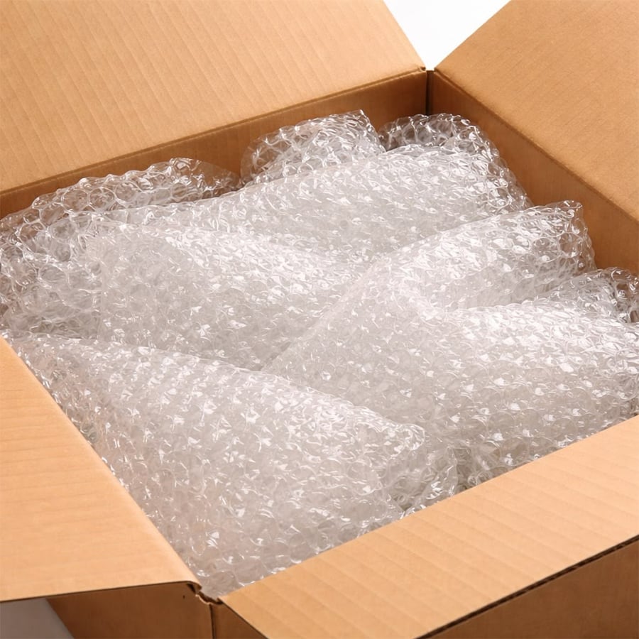 A cardboard box filled with sheets of clear bubble wrap, used for protecting items during shipping.