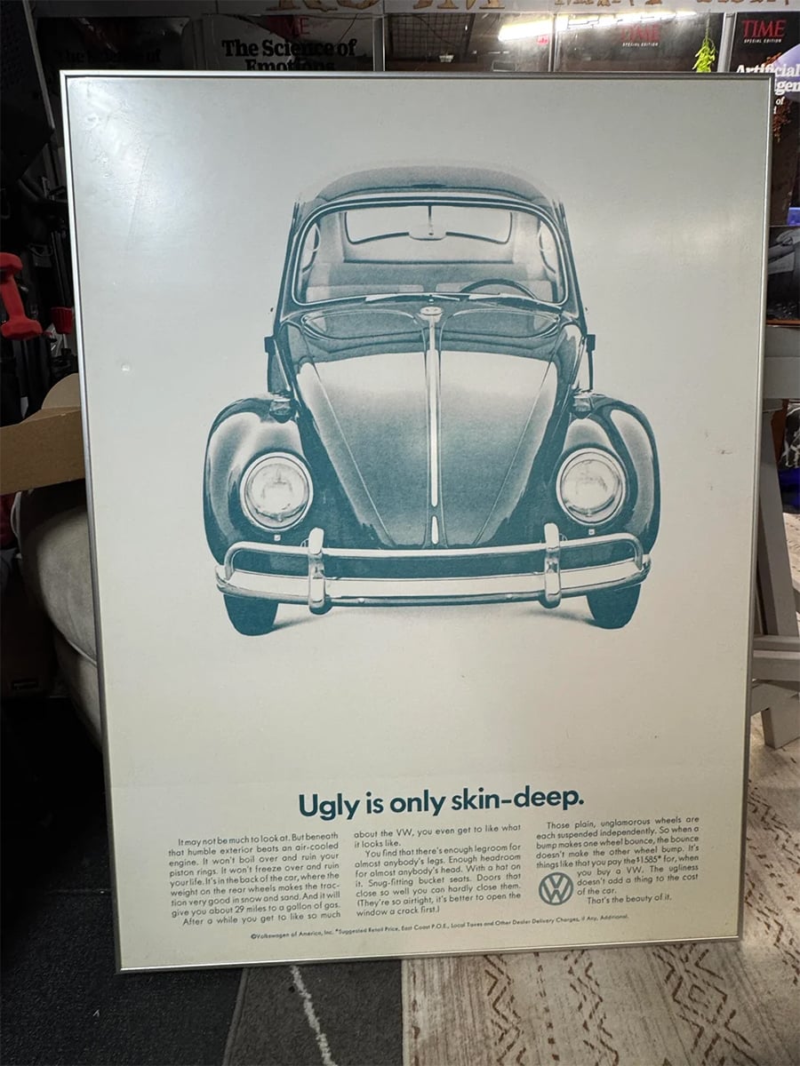 A vintage Volkswagen Beetle advertisement poster featuring a front view of the car with the headline “Ugly is only skin-deep.” Text below discusses the car’s appeal despite its unconventional appearance.