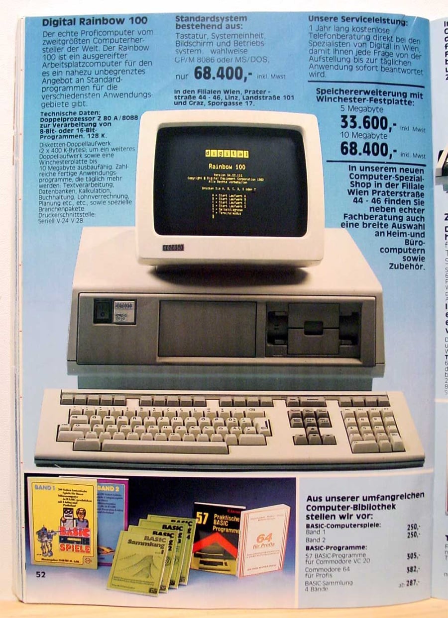 A vintage advertisement for the Digital Rainbow 100 computer, showing a monitor, CPU, and keyboard on a blue background, with German text and books displayed at the bottom.