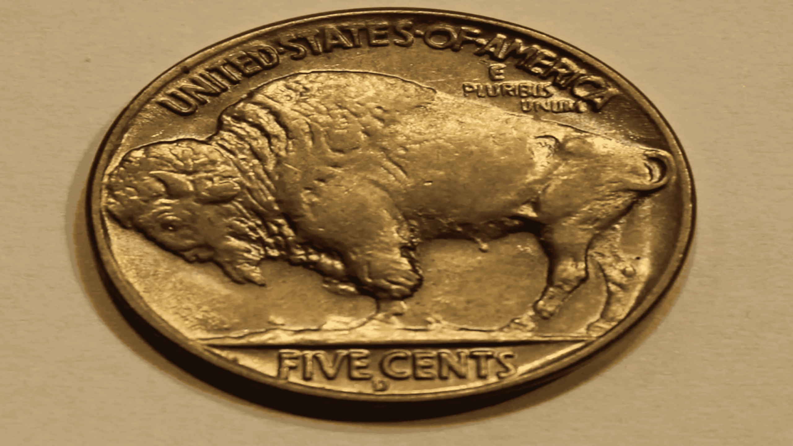 A vintage United States nickel shows a buffalo on one side with “UNITED STATES OF AMERICA,” “E PLURIBUS UNUM,” and “FIVE CENTS” engraved.