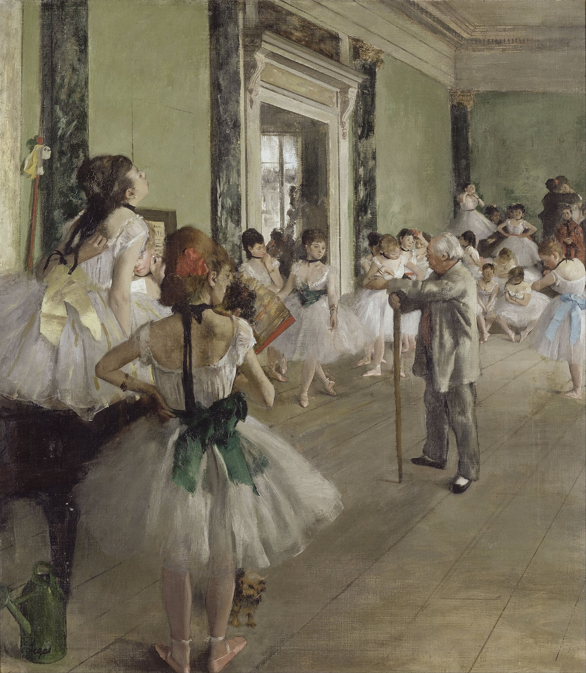 A ballet class with young girls in white tutus gathers in a spacious studio as an older instructor with a cane observes. Some girls practice while others stand and wait, with sunlight streaming in from windows.